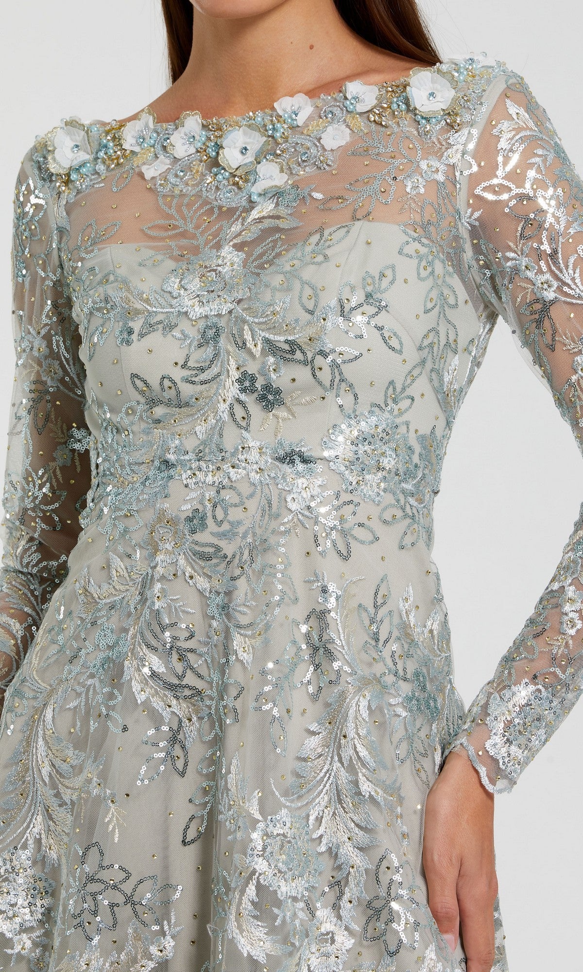 A woman wearing the Mac Duggal 68898 Midi Party Dress, featuring long sheer sleeves, silver and blue floral embroidery, delicate sequin embellishments, and 3D flower details along the neckline.